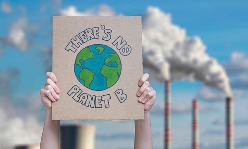 Climate change manifestation poster on an industrial fossil fuel burning - Shutterstock